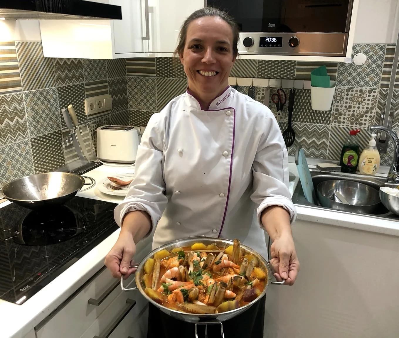 Chef Margarida Vargues holding a cataplana of seafood, fresh from the stove