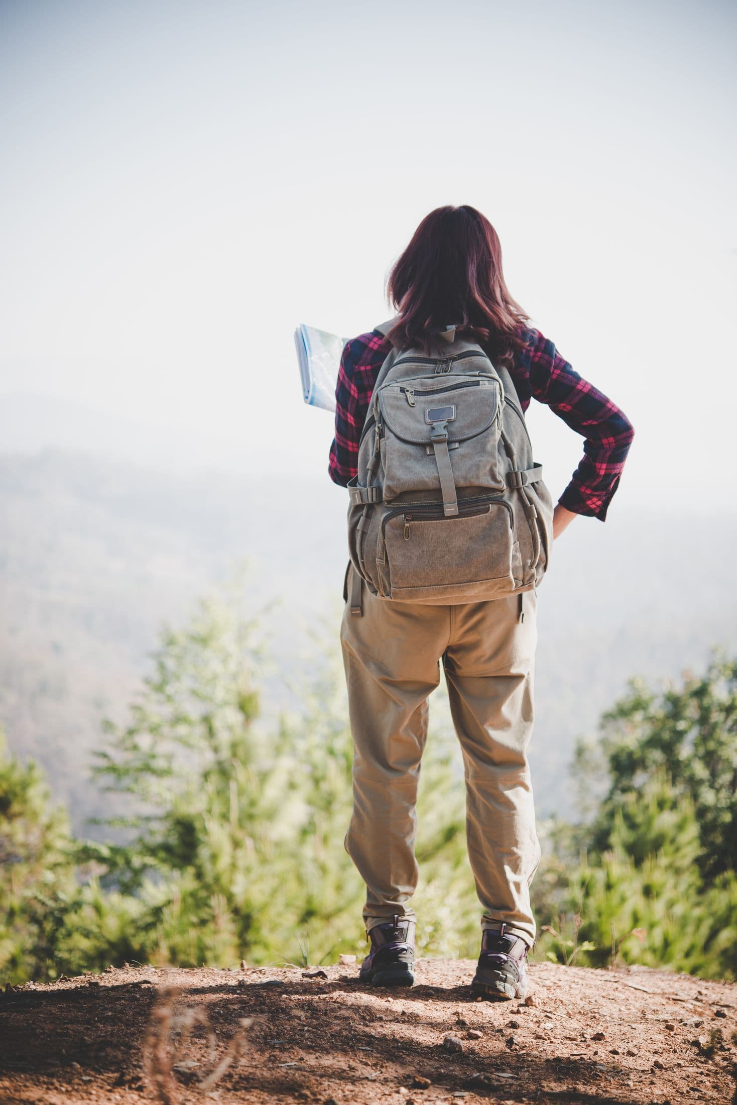 A walker reading a map on a mountain trail