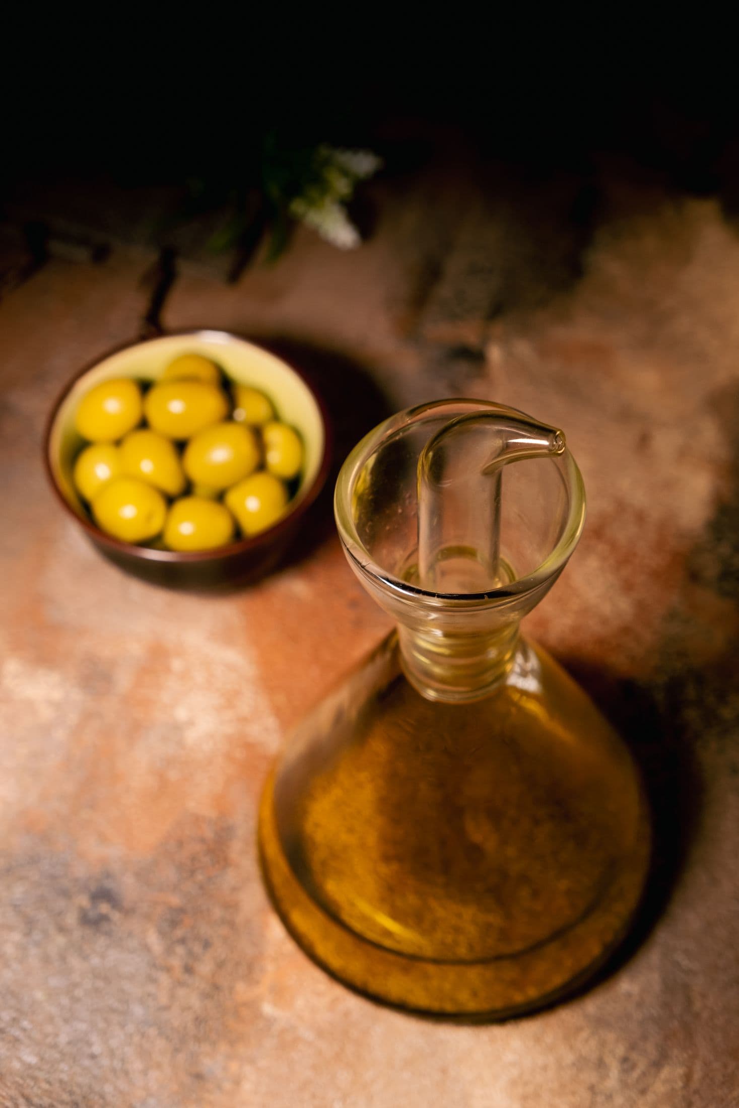 Olive oil and olives on a rustic wooden table